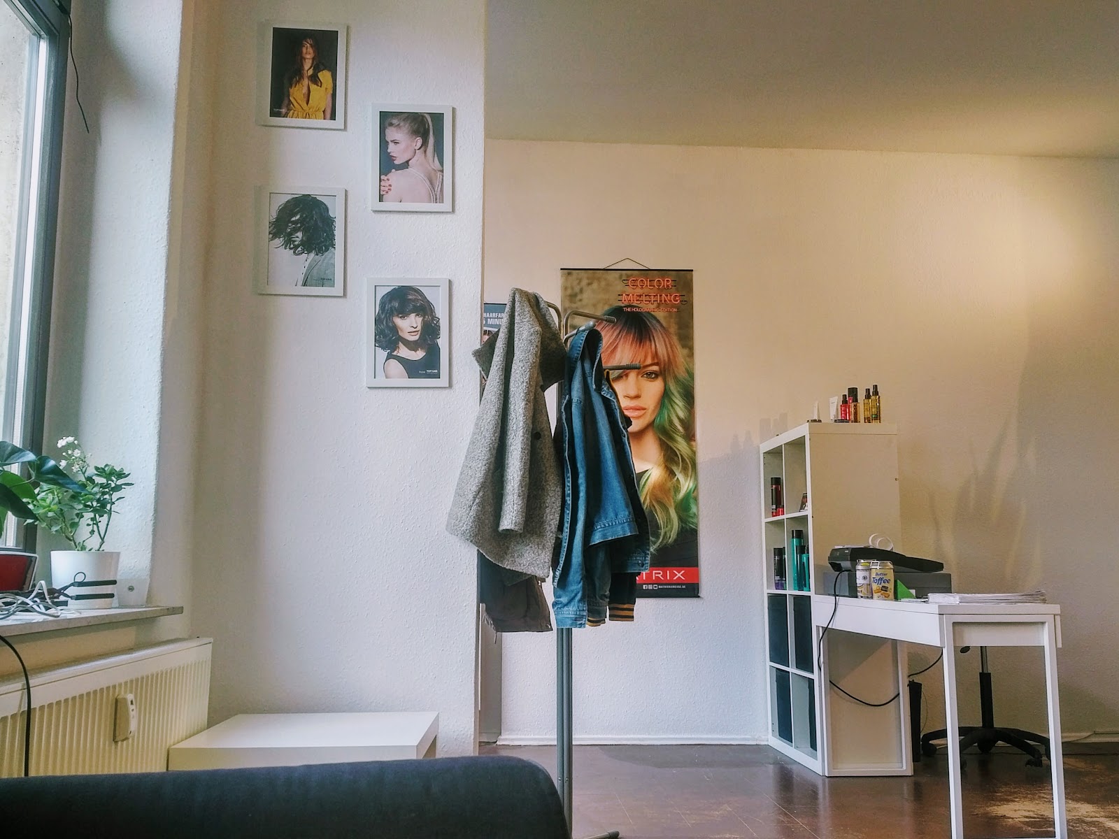 Empfangsbereich im Haarstützpunkt mit Frisurenbildern an der Wand